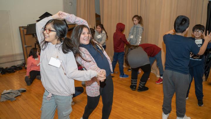 Two young teenage girls dancing and laughing