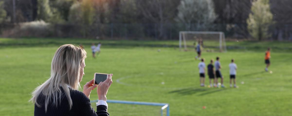 Mom taking photo of kids game